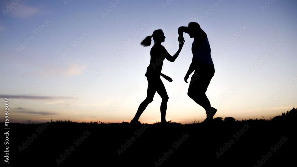 silhouette of a couple dancing against blue sky silhouette of a couple dancing against blue sky