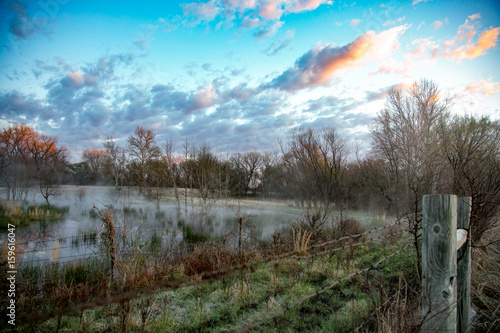 Eerie morning mist over a pond on the autumn countryside