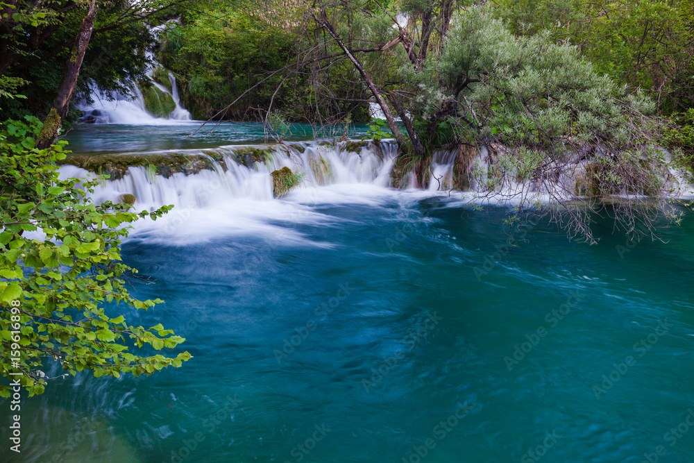 Fototapeta premium Beautiful summer green forest waterfall