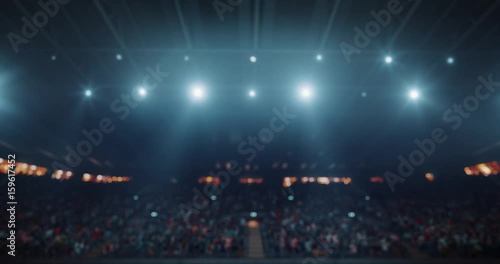 4k video footage of an indoor floodlit basketball arena full of spectators. photo
