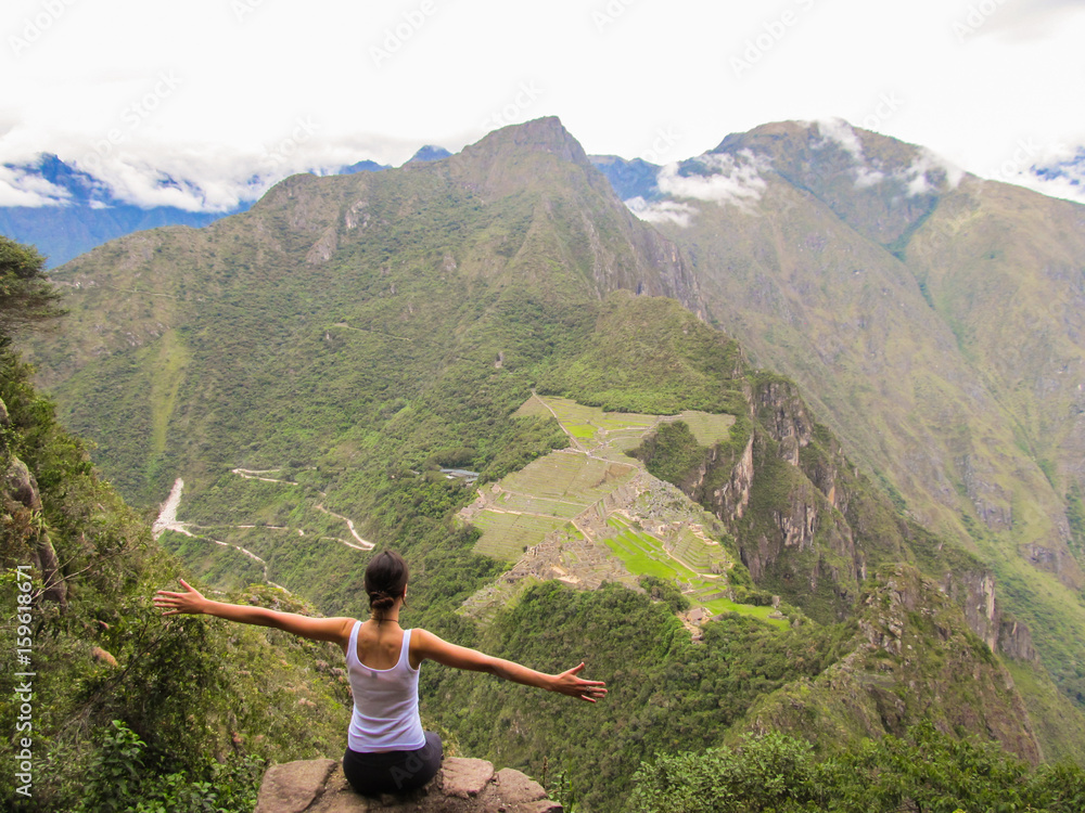 Woman at the top of Wayna Picchu mountain in Machu Picchu, Peru