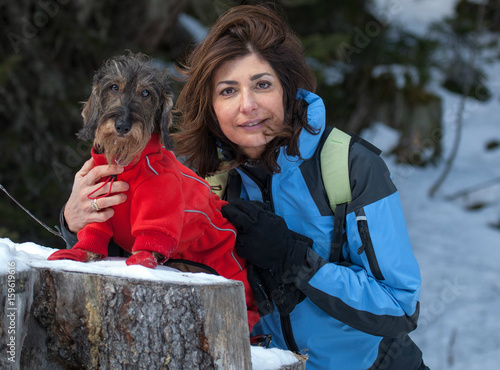 Coppia bassotto e padrona sulla neve photo