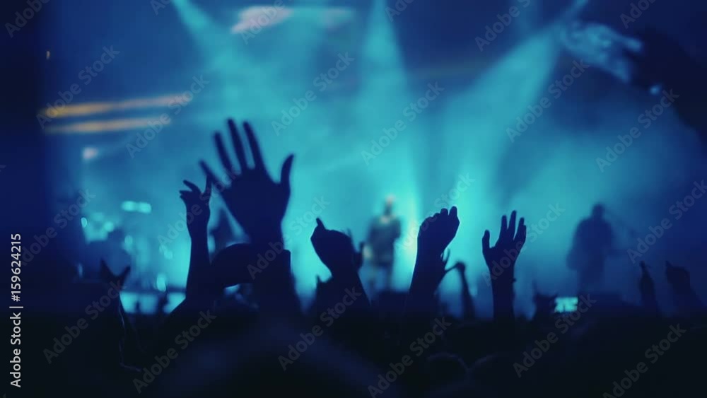 Iconic night rock concert front row crowd cheering hands in air slomo ...