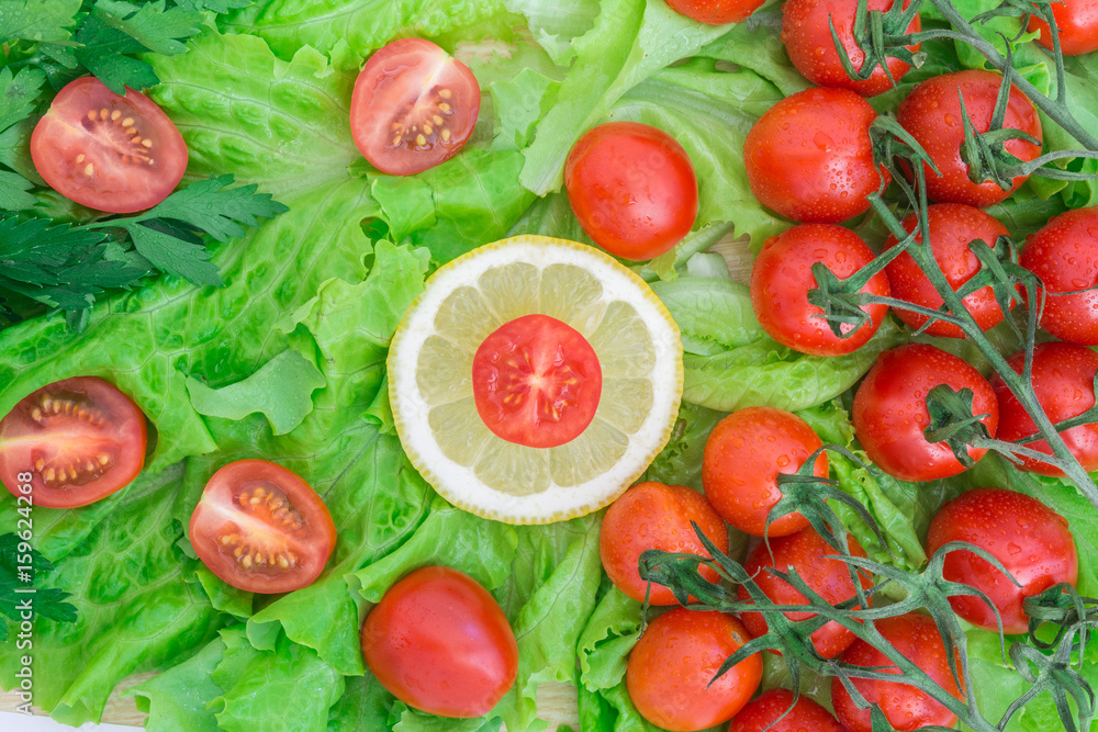 Cherry tomatoes covered with water drops lie on the basis of green lettuce leaves Cherry tomatoes covered with water drops lie on the basis of green lettuce leaves