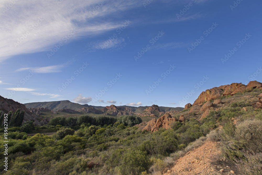 Daytime landscape, arid mountains, blue sky and thin cloud