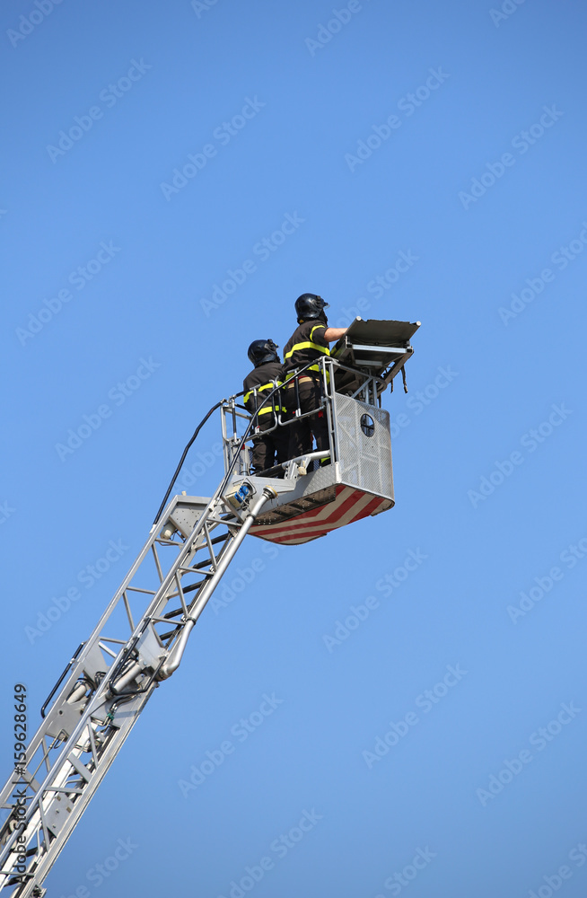 Two intrepid firefighters over the autoscale metal basket during