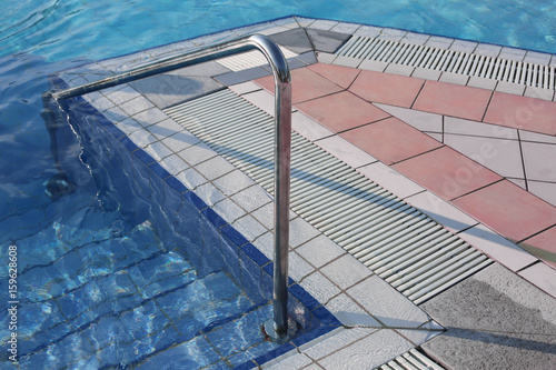 swimming pool with ladder and the steel handrail in an exclusive resort