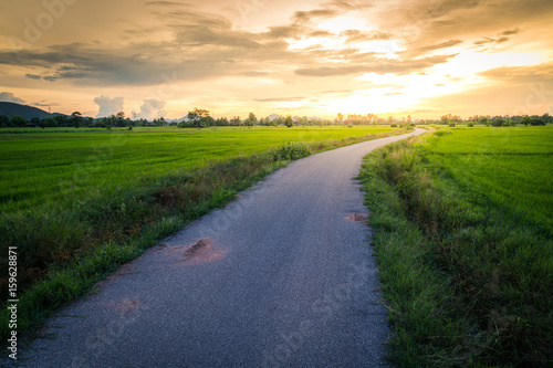 Picturesque landscape scene and sunrise above road