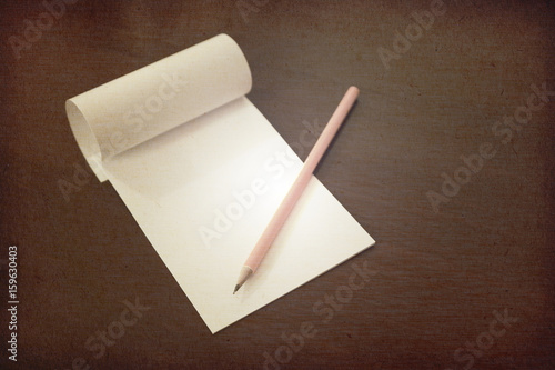 Pencil laying on blank note paper, Creative work, writing, drawing concept. vintage toned with paper textures image.
