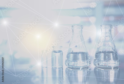 flask ans vial glassware in laboratory with light polygon  background