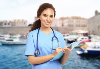 Beautiful African American female doctor on white background