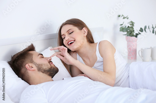 Cute young couple in bed at...