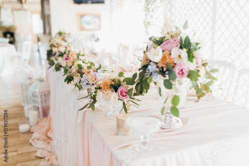 Pink wedding decoration with white and green flowers © shunevich