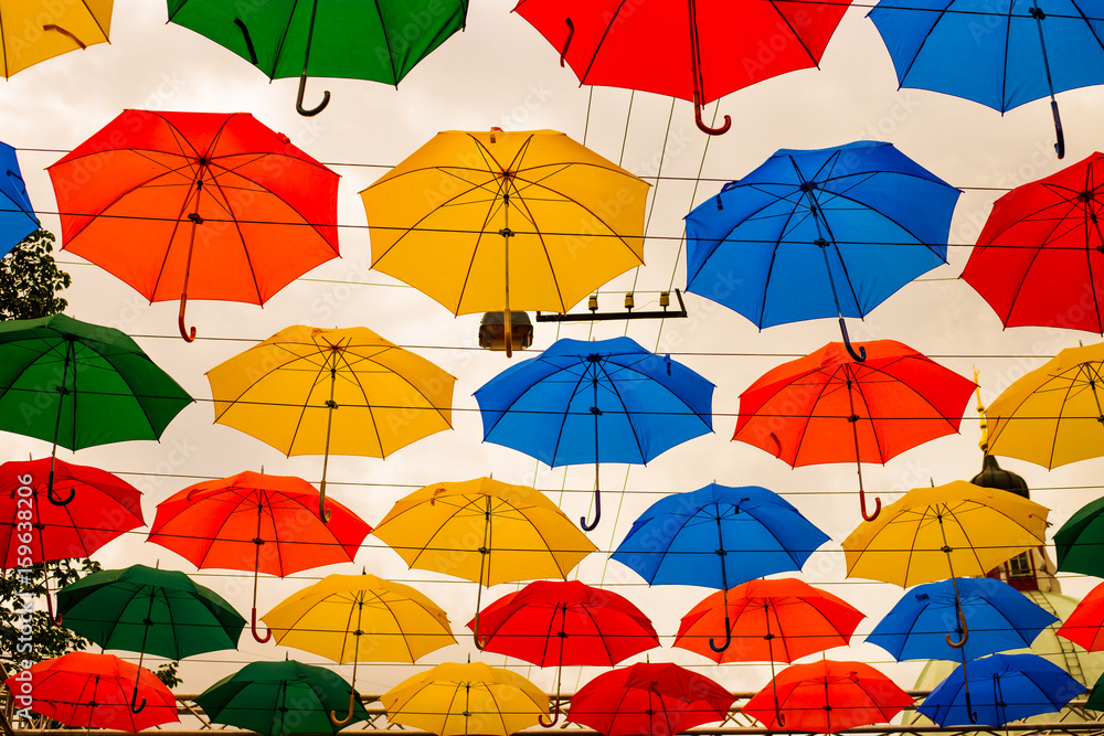 Colorful hundreds of umbrellas floating above the street