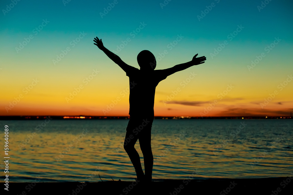 Silhouette of man on the background of the sea and sunset Silhouette of man on the background of the sea and sunset