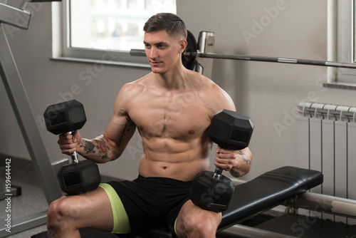 Man Preparing To Doing Shoulders Exercise With Dumbbells