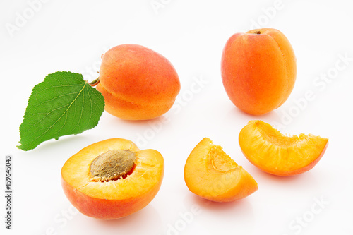 Leinwand Poster Ripe, juicy and appetizing apricot fruits with green leaves
