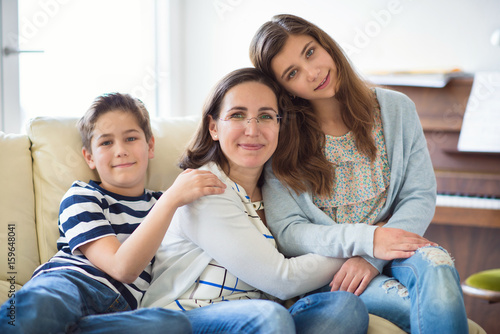 Portrait of pretty young mother with her tennager daughter and son