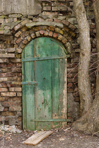 The old wooden door on the ruined wall. © Nedilko