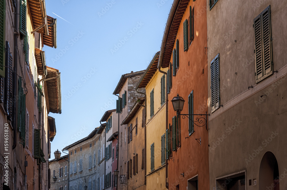 SAN QUIRICO D'ORCIA, ITALY - OCTOBER 30, 2016 - Charming narrow street in the town of San Quirico d'Orcia, province of Siena, Val d'Orcia, Tuscany, Italy