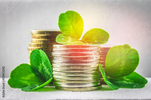 Stacks of Russian coins with clover leaves on a gray background with droplets of water. St.Patrick 's Day. photo