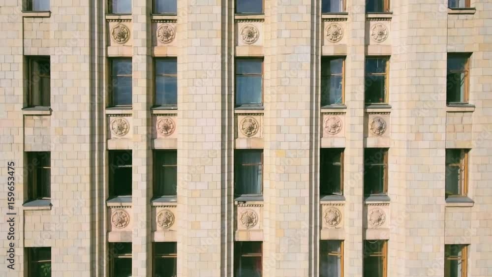 Aerial shot along the High-rise multi-storey vintage building with a large number of windows and stucco moldings. Summer day in the sunlight. Main building of Moscow State University, close-up Aerial shot along the High-rise multi-storey vintage building with a large number of windows and stucco moldings. Summer day in the sunlight. Main building of Moscow State University, close-up