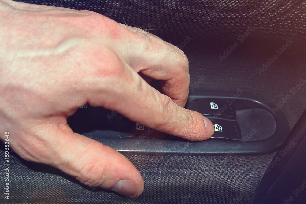 hand close-up pushes window lift button in the car hand close-up pushes window lift button in the car