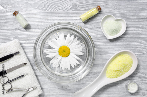 Hand care with chamomile and spa salt top view on wooden desk