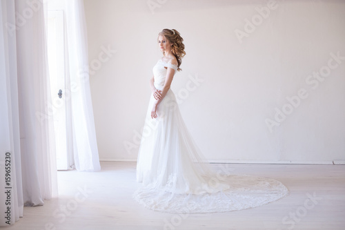 bride in wedding dress in a white room