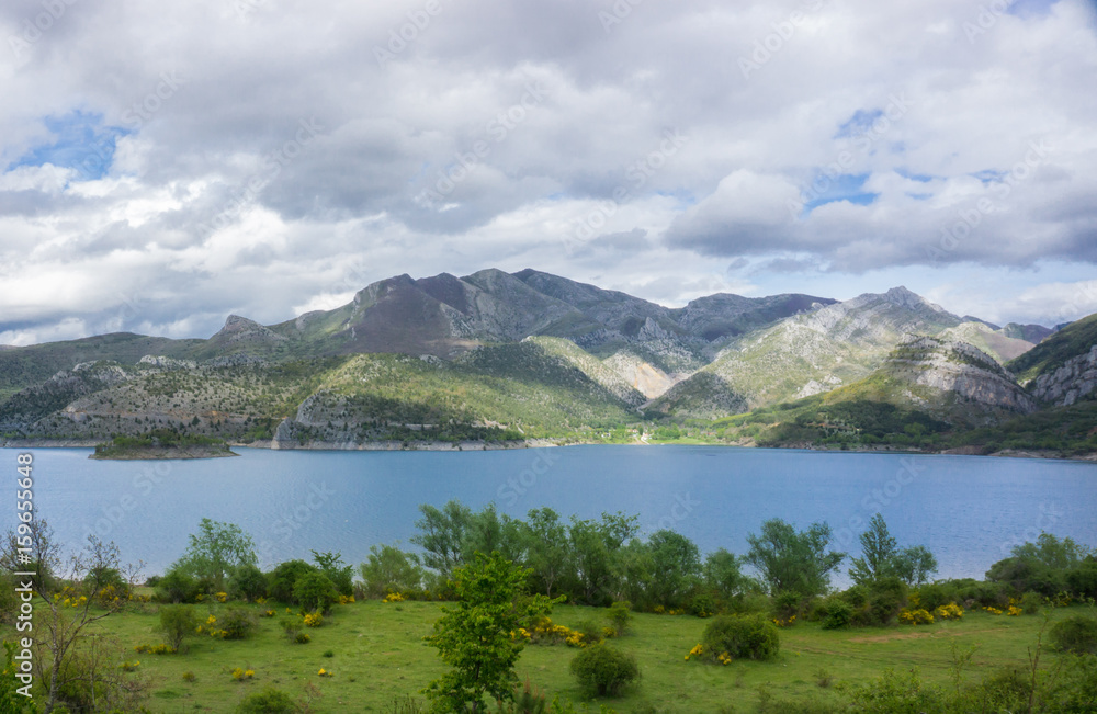 Beautiful mountain lake in Spain, Asturias region in summer, with dramatic sky and a lot of clouds