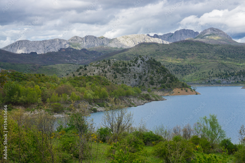 Beautiful mountain lake in Spain, Asturias region in summer, with dramatic sky and a lot of clouds