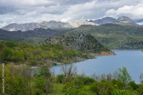 Beautiful mountain lake in Spain, Asturias region in summer, with dramatic sky and a lot of clouds