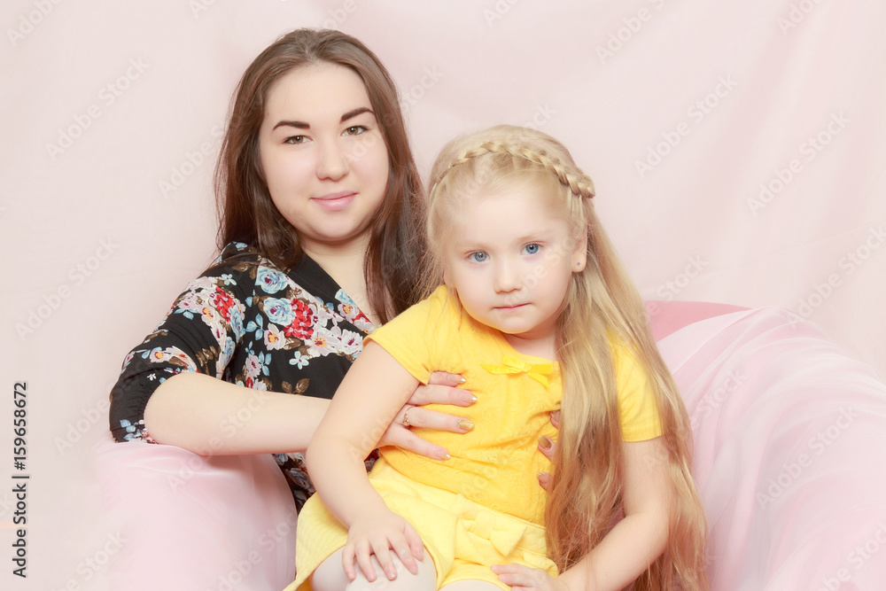 2 sisters are sitting on the couch. 2 sisters are sitting on the couch.
