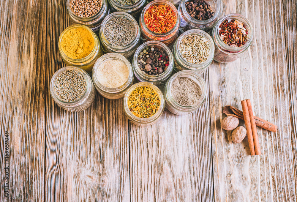 Various colorful kinds of spices on rustic wooden table, top view with copy space Various colorful kinds of spices on rustic wooden table, top view with copy space