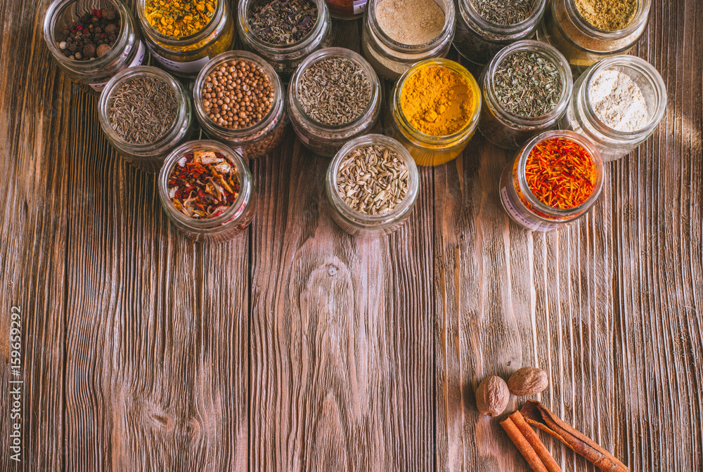 Various colorful kinds of spices on rustic wooden table, top view with copy space Various colorful kinds of spices on rustic wooden table, top view with copy space