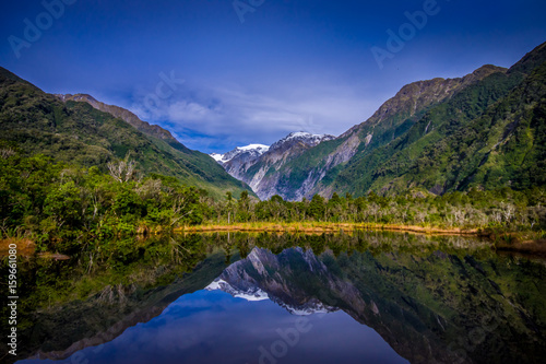 Small pond peters pond with reflection of mountain glacier Franz Josef Glacier in New Zealand photo