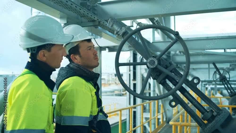 Worker rotating wheel at large oil refinery Worker rotating wheel at large oil refinery