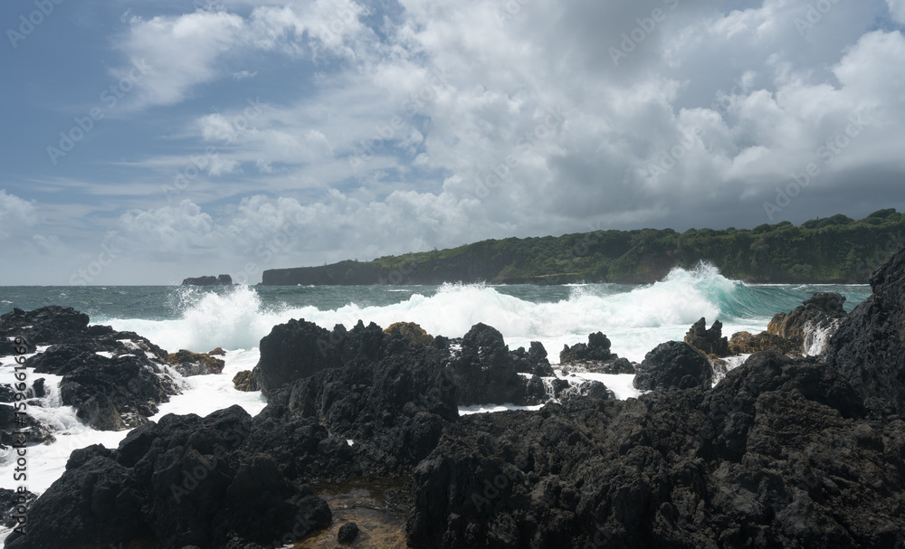 Pacific ocean breaks against lava rocks at Keanae