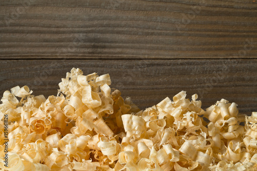 Light brown wood shavings from carpenter's hand planer or chisel work on wooden boards photo