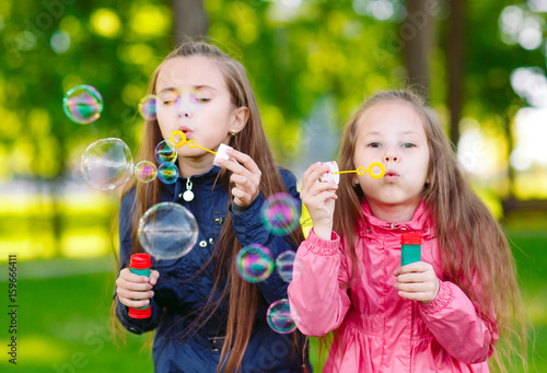 Girls play with soap bubbles.