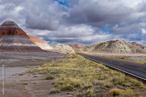 The Blue Mesa member of the Chinle Formation in the background with the open road through the Petrified Forest National Park  AZ in the foreground.