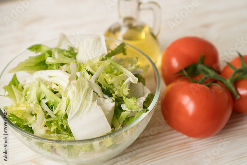 Healthy veggie salad ingridients. Tomato, lettuce and olive oil.