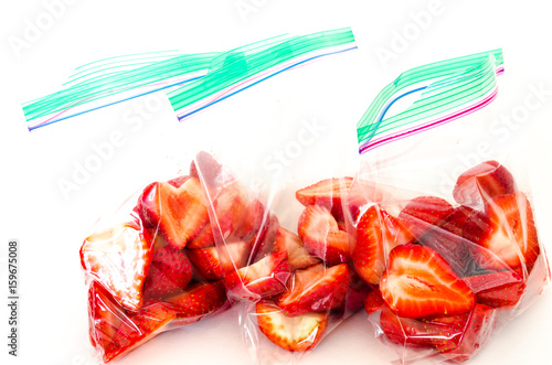 Studio shot fresh chopped strawberries in three clear plastic bag with lock isolated on white. In-house cut, packed strawberry in transparent zipper bags to-go/take away. Convenience, healthy concept.