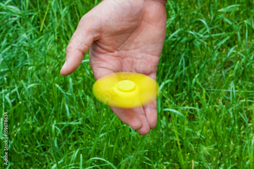 Rotating yellow spinner on male finger