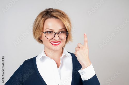 Beautiful business woman showing finger up and smiling looking up