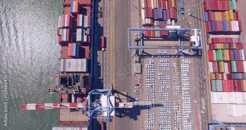 Aerial Time lapse - Commercial port with container ships, Top down view.