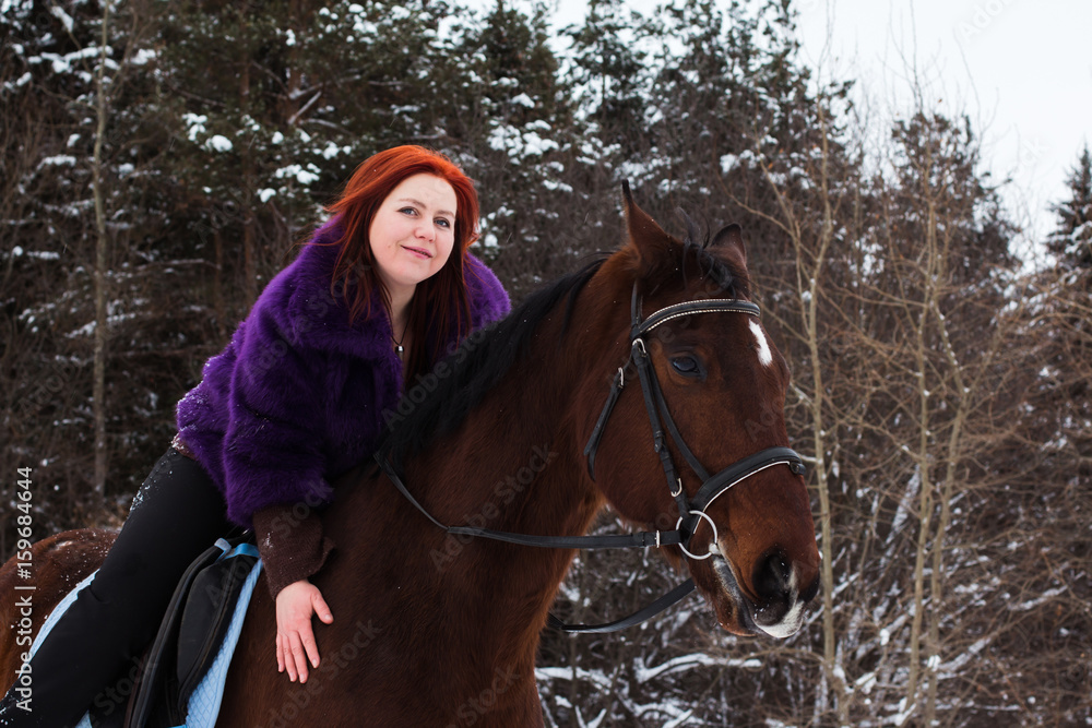 Woman with red hair and big horse outdoor in winter Woman with red hair and big horse outdoor in winter