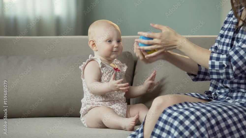 Funny active baby girl playing with mother, happy family enjoying time together Funny active baby girl playing with mother, happy family enjoying time together