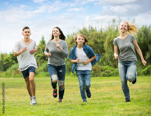 Teenagers friends running on meadow