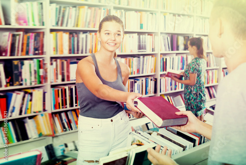 Smiling girl getting help with book choice